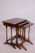 A nest of three mahogany occasional tables, with crossbanded tops, raised on ring turned supports,