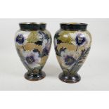 A pair of Doulton Lambeth bulbous vases with raised floral and tube lined decoration marked for