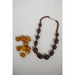 A string of bi-colour horn graduated beads, together with a quantity of loose amber style beads,