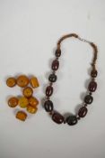 A string of bi-colour horn graduated beads, together with a quantity of loose amber style beads,