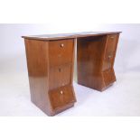 A mid C20th mahogany kneehole desk with inset leatherette top and two drawers over four fall front
