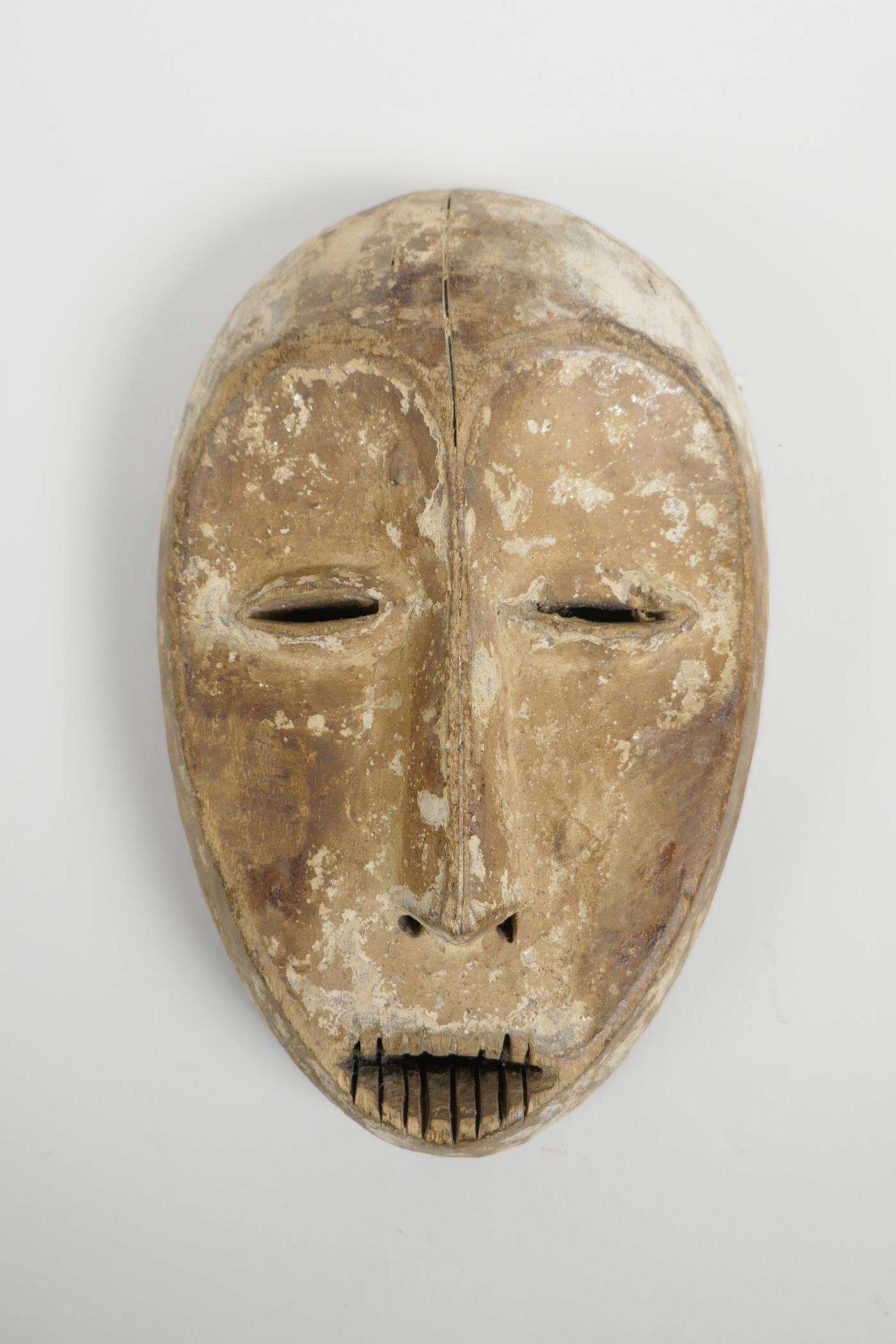 An African carved wood and white clay mask, probably from the Ngbandi, Ngbaka and Ngombe tribal