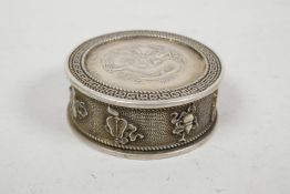 A Chinese white metal coin box and cover, the sides decorated with the emblems of the Eight