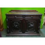A C19th Flemish oak buffet, with carved game birds and lion mask decoration, comprising two