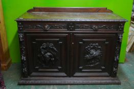 A C19th Flemish oak buffet, with carved game birds and lion mask decoration, comprising two
