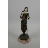 A late C19th bronze and faux ivory figure of a young woman dressed in Arab clothing looking in her