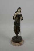 A late C19th bronze and faux ivory figure of a young woman dressed in Arab clothing looking in her