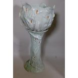 An Art Nouveau style pottery jardiniere on stand of embossed organic form decorated with embossed