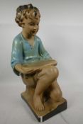 A plaster advertising figure in the form of a seated boy with tray, 21" high