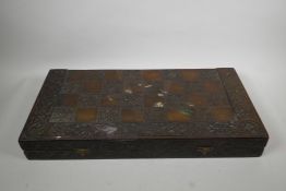 A pressed wood chessboard, opening to reveal a backgammon board and composition pieces, 12" x 24"