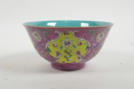 A Chinese polychrome porcelain rice bowl with decorative floral panels on a pink ground, seal mark