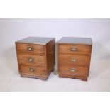A pair of mahogany campaign style side chests of three drawers, with tilt tooled leather tops and