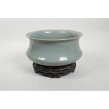 A Chinese Ru ware style celadon crackle glazed bowl on a carved hardwood stand, the base with an
