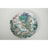 A Chinese famille verte porcelain charger decorated with a dragon clutching the flaming pearl, 6