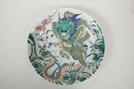 A Chinese famille verte porcelain charger decorated with a dragon clutching the flaming pearl, 6