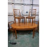 A mid century teak and mahogany pull out dining table with fold out leaf, 36" x 60" x 78"