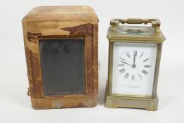 A French brass cased carriage clock with white enamel dial and Roman numerals, retailed by