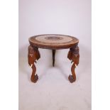 A Burmese hardwood occasional table on carved elephant head feet, the tabletop with carved detail of