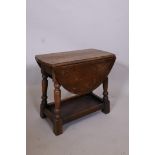 An oak swivel top dropleaf occasional table on turned supports united by an undertier, 19½" x 11",