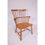 A mid C20th beechwood comb back elbow chair