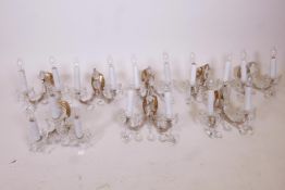 A set of seven two-branch glass wall lights with lustre drops and a matching three-branch light,