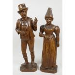 A pair of Bavarian Black Forest carved wood figures of a lady and Gentleman dressed in traditional