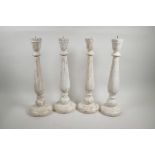 A set of four painted and distressed turned wood pricket candlesticks, 18" high