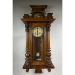 A late C19th Vienna wall clock, walnut, with enamel dial, Roman numerals and decorative pedestal