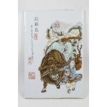 A Chinese polychrome porcelain panel decorated with a sage riding a buffalo being led by a child,