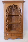 A pine hanging corner shelf with pierced grape and vine decoration and single drawer, 49" x 29"