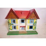 A mid C20th hand painted doll's house in plywood, with two opening doors at the front to reveal