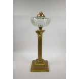 A brass Corinthian column adapted oil lamp with a glass reservoir, 20" high