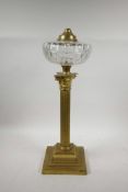 A brass Corinthian column adapted oil lamp with a glass reservoir, 20" high