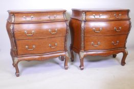 A pair of oak veneered bombe shaped commodes with three long drawers and brass mounts, 34" x 17½",
