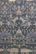 A framed Indonesian green ikat textile depicting figures, animals and temples, 36" x 39"