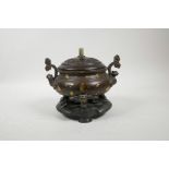 A Chinese two handled bronze censer on tripod supports with gilt splash decoration, a turned and