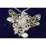 An Art Nouveau style silver pendant/brooch with face mask and plique a jour butterfly wings and