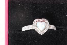 A silver, cubic zirconium and opalite heart shaped ring, size P/Q