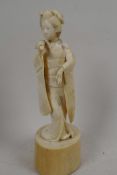 A 1920s Japanese carved ivory figure of a geisha with a fan, 6¼" high