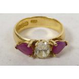 A 22ct yellow gold diamond and ruby ring, the central oval cut diamond ring flanked by two pear