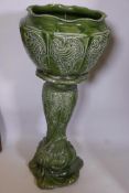 A green glazed pottery jardiniere pedestal of organic form with all over green glaze, 33" high