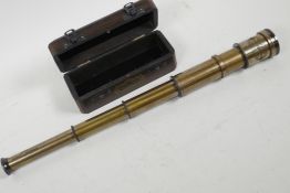 A three draw brass telescope in fitted hardwood box, bears label 'Dolland' London, 17" long extended