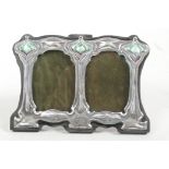 An Art Nouveau style sterling silver double photo frame with green enamel decoration, apertures