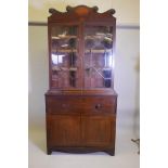 A Regency mahogany secretaire bookcase with inlaid decoration, the fall front secretaire fitted with