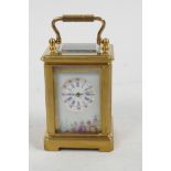 A miniature brass cased carriage clock with floral decorated porcelain panels and circular dial with