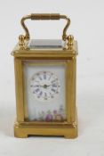 A miniature brass cased carriage clock with floral decorated porcelain panels and circular dial with