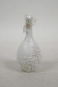 A Chinese moulded porcelain snuff bottle decorated with a riverside landscape, impressed mark to
