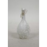 A Chinese moulded porcelain snuff bottle decorated with a riverside landscape, impressed mark to