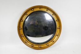 A Georgian style giltwood convex wall mirror, set in a round moulded frame with ball decoration