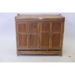 An unusual bamboo low cabinet with four doors revealing shelved interior, 24" high, 28" wide, 12"